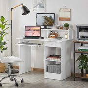 Angled view of the white Oakcraft writing desk with laptop, lamp and open shelves